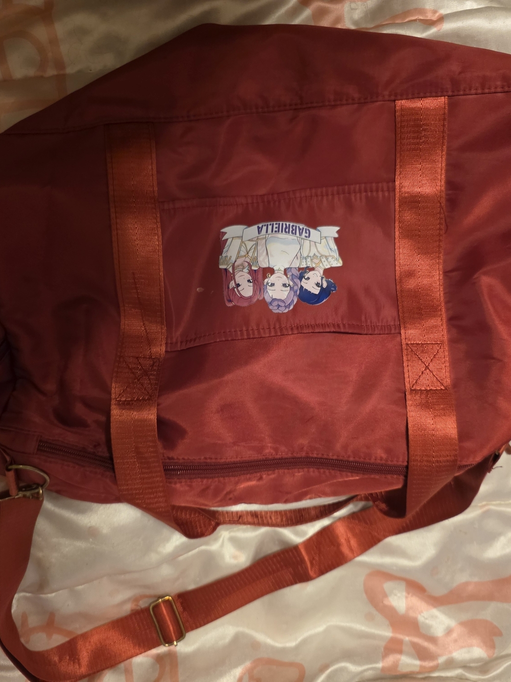 Red Nylon Travel Duffel Bag with Huntrix On It That Reads Gabriella